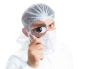 Medical staff member with a magnifying glass in front of his eye; isolated on white background
