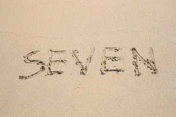 Number seven on the Sand. Concept holiday background.