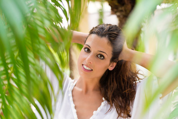 Wellness and beauty concept. Natural woman portrait at tropical garden. Tranquil female on summer vacation.