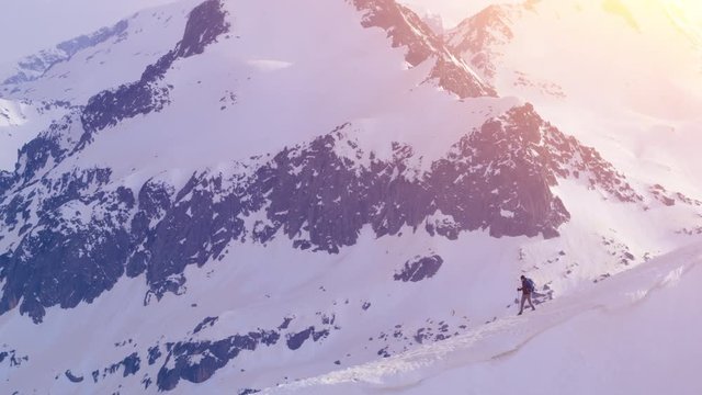 Aerial Drone Flight Over Mand Walking Down a Dangerous Beautiful Mountain Cliff Edge Adventure Extreme Environment Danger Concept