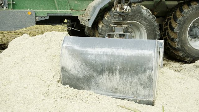 The big clamp of the backhoe getting limestones in powder form from the limestone quarry area