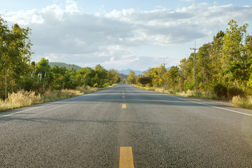 panoramic view of hot summer road with green trees around