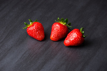 tasty strawberries isolated on black background, stone tile