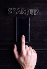 Hand of man writing on smartphone, start up sign