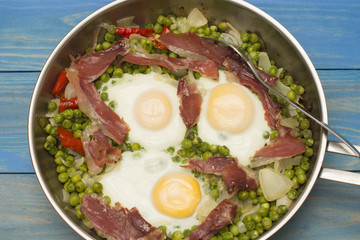 huevos con guisantes y jamon, comida en la sarten