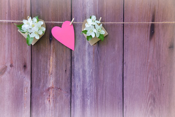 Apple blossom and heart on wooden background.Romantic toning.