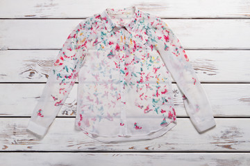 White shirt with butterfly print.
