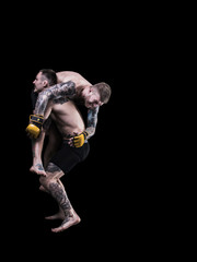 Mixed martial artists fighting on black background