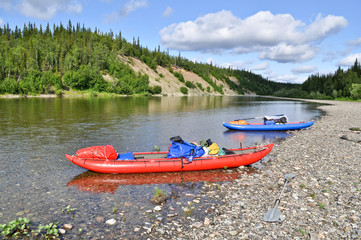 Fototapeta na wymiar Inflatable kayaks on the shore taiga rivers.