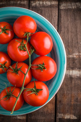 Tomatoes branch on old rustic wooden table and dark background