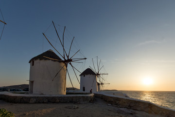 Fototapeta na wymiar Sunset at White windmill on the island of Mykonos, Cyclades 
