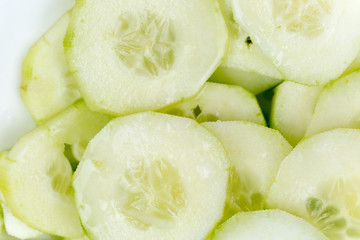 Sliced cucumbers on the plate, macro close up flat lay.