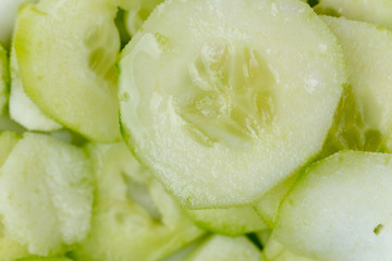Sliced cucumbers on the plate, macro close up flat lay.