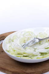 Fork in cucumbers salad with onions and sour cream