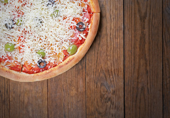 Pizza with cheese on wooden table background