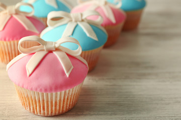 Tasty cupcakes with bow on grey background
