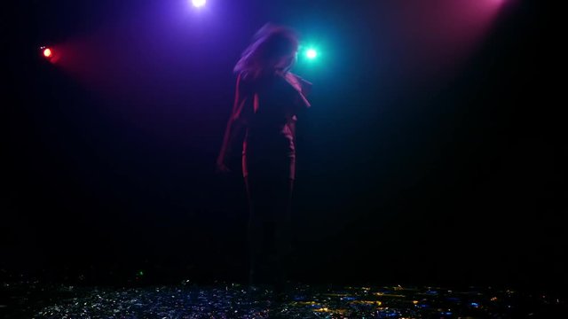 Rhythmic dance of silhouette girl with disco style lights