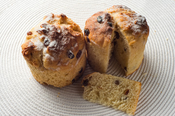 pair of homemade carrot muffins on white fabric background. top view