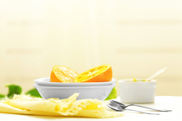 Eating oranges with spoon on white table