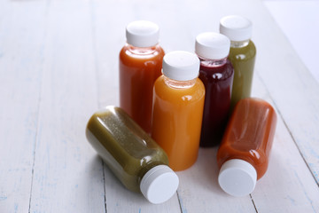 Diet concept: vegetable juices in bottles on wooden background