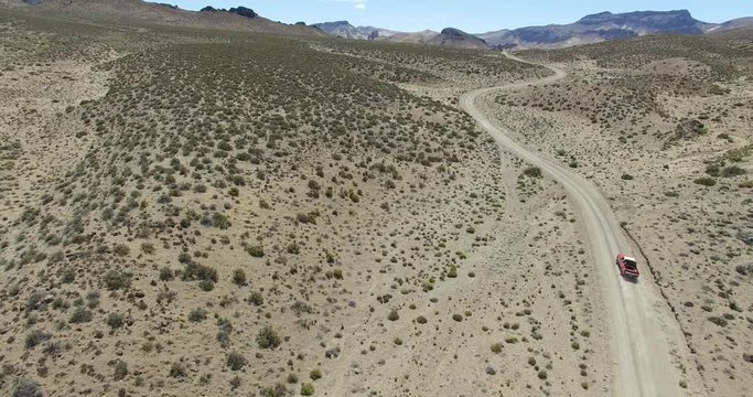 Aerial drone scene of dry, desert mointainous landscape. High perspective of dry panorama with dirt road. Starts from lower altitud to a higer visual.  Patagonia, argentina, Chubut, Piedra Parada. 
