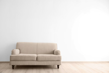 Cozy couch on wall background