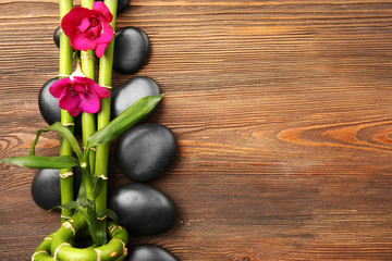 Beautiful spa composition with stones and orchids on wooden background