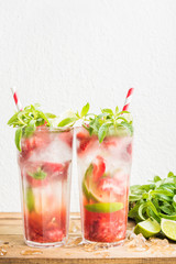 Strawberry mojito summer cocktails with mint and lime in tall glasses