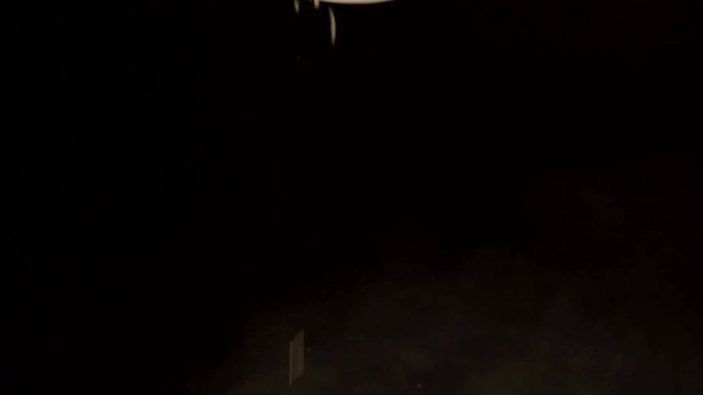 Cumin falling from wooden spoon on a black background. Close up. Slow motion