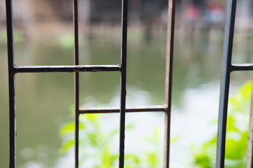 Brown metal grid window with blur canal background