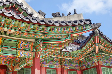 Fototapeta na wymiar Korean traditional architecture. Roof detail of palace in Seoul. These places are major tourist attraction of South Korea.
