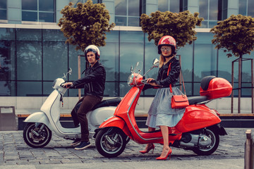 Male and female having fun on moto scooters.