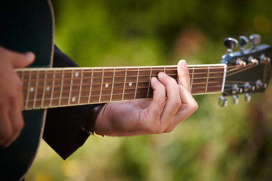 A man playing chords on guitar.
