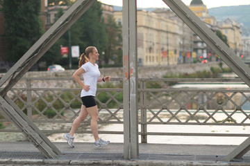 sporty woman running  on sidewalk