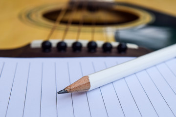 Fototapeta premium Guitar and Blank notepad with pencil