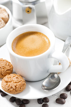 cup of espresso and cookies on a white table, vertical, closeup