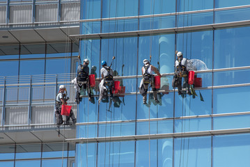 Group of window cleaners suspended from cables