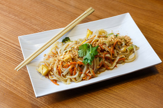 Rice noodles with tofu and vegetables  in rectangle plate  in asian restaurant