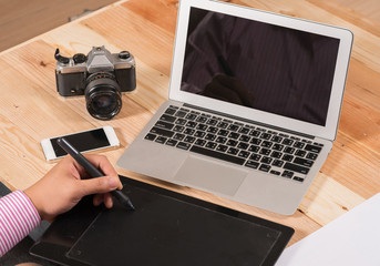 Graphic designer using digital tablet and computer in the office
