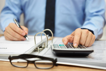 Hands of accountant with calculator,documentation and pen. Accou