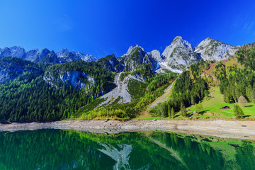 The snow-covered peaks in the Alps with a beautiful green mounta