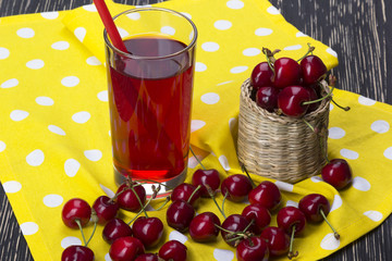 Cherry baskets and juice on wooden background