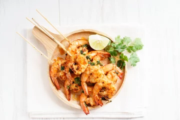 Zelfklevend Fotobehang grilled shrimp kababs with sriracha and lime. © shersor