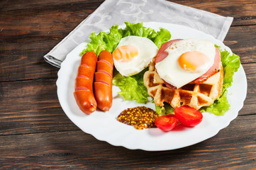 Belgian waffle with egg and sausage on wood table