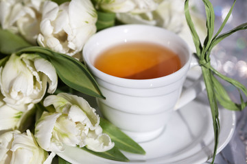 Чай в белой чашке и букет тюльпанов