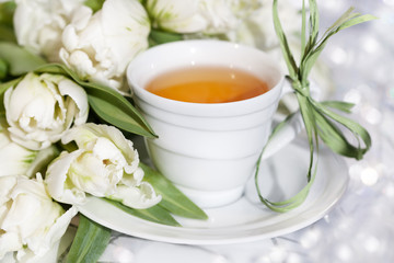 Чай в белой чашке и букет тюльпанов