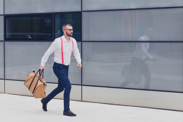 Young caucasian businessman running with a bag. Copy space
