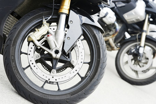 Two motorbike front wheels lined up in a row. Close up image.
