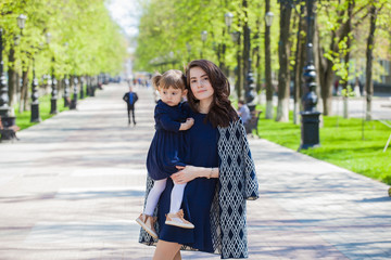 Mom and daughter on a walk in the summer park