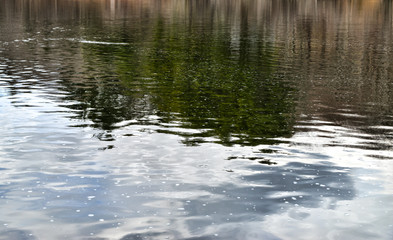 Rippling water with sky and trees reflected